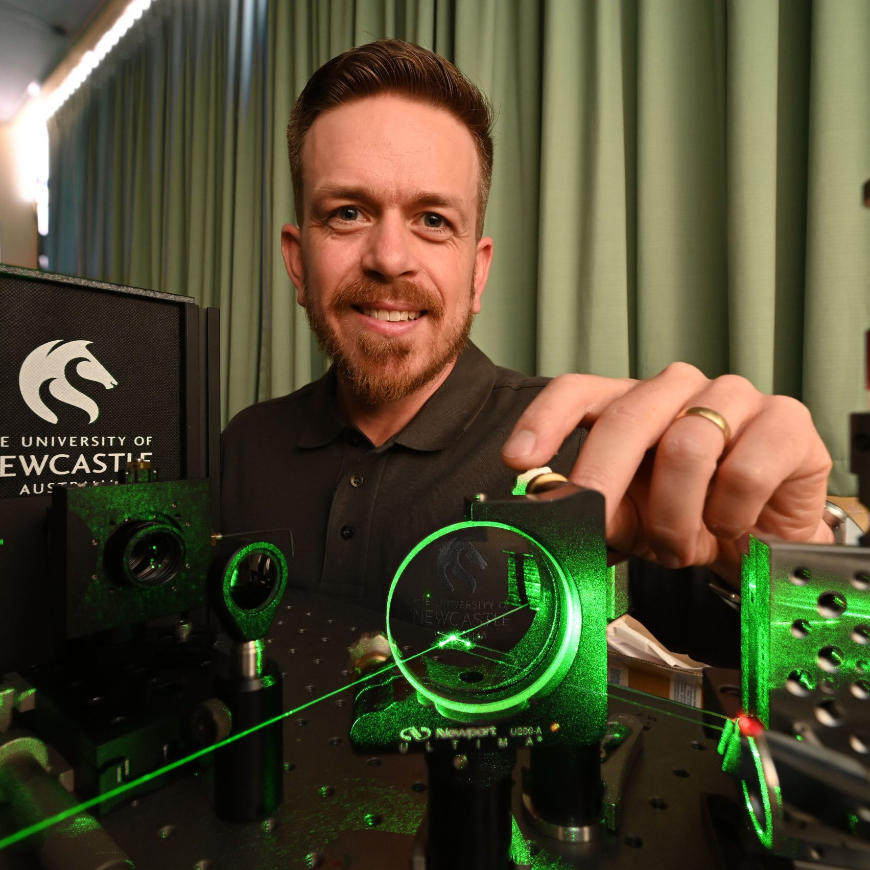 Lachlan Roberts shing a laser and smiling at the camera